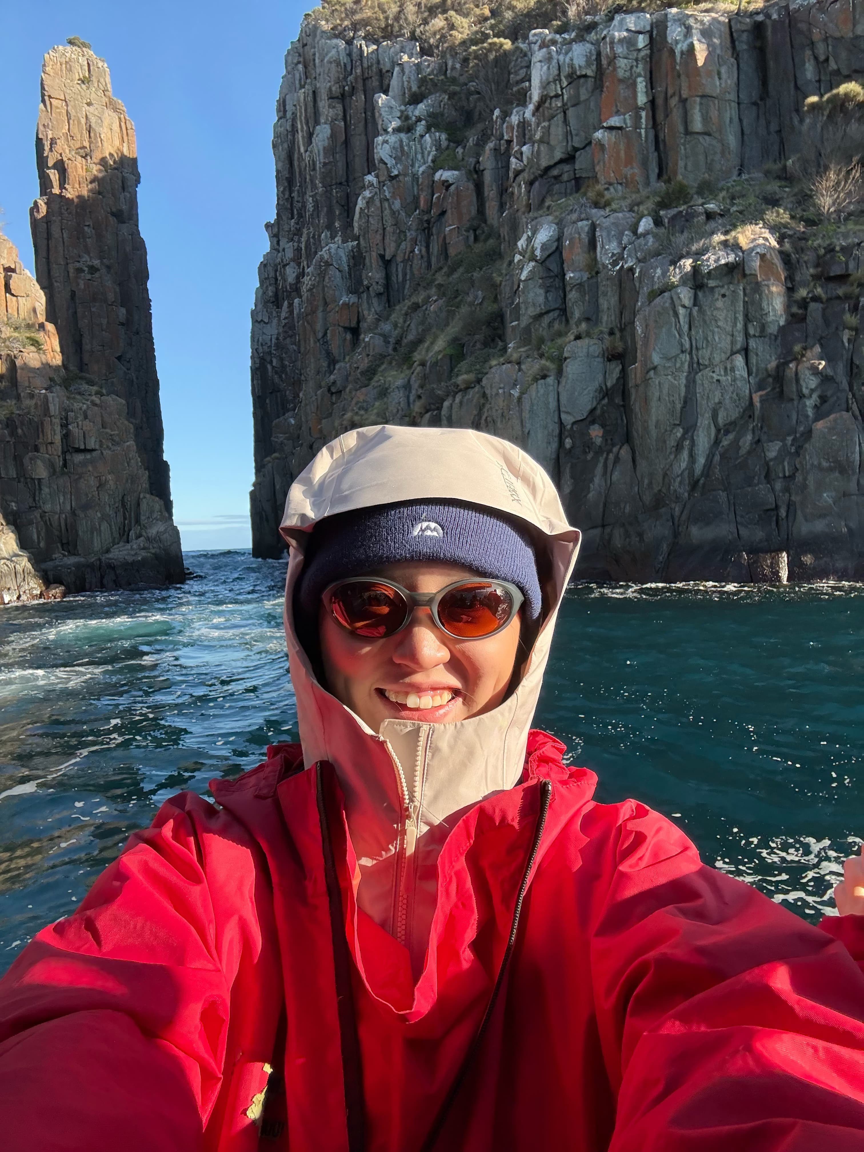 Eryou in a red jacket beside coastal cliffs